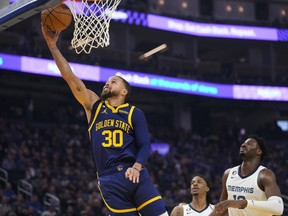 Warriors guard Stephen Curry, left, shoots against the Grizzlies during first half NBA action in San Francisco, Wednesday, Jan. 25, 2023.