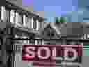 A sold sign is shown in front of west-end Toronto homes, Sunday, April 9, 2017.