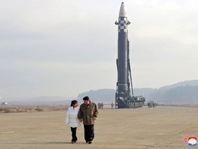 North Korean leader Kim Jong Un, along with his daughter, walks away from an intercontinental ballistic missile (ICBM) in this undated photo released on November 19, 2022 by North Korea's Korean Central News Agency (KCNA).