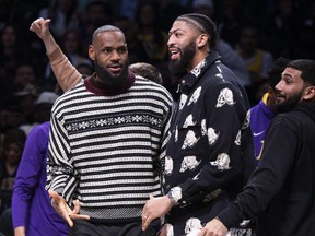Los Angeles Lakers forward LeBron James, left, and forward Anthony Davis look on from the bench during the second half of an NBA basketball game against the Brooklyn Nets, Monday, Jan. 30, 2023, in New York.