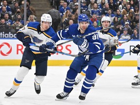 Maple Leafs' John Tavares (right) is covered by St. Louis Blues' Niko Mikkola during the first period at Scotiabank Arena on Tuesday. Jan. 3, 2023.