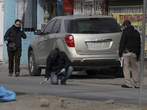 Experts from the Chihuahua Prosecutor check for bullets outside the prison of Ciudad Juarez number 3 after an attack in Ciudad Juarez, Chihuahua state, on January 1, 2023.