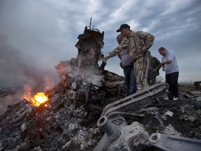 People inspect the crash site of a passenger plane near the village of Hrabove, Russian-controlled Donetsk region of Ukraine on Thursday, July 17, 2014.