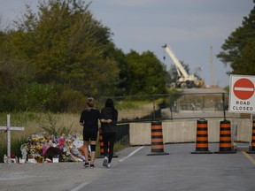 Friends and family visit a memorial near the site of an accident that killed six young people in Barrie, Ont. on Saturday, September 3, 2022. Police have charged a construction company in connection to a fatal crash in Barrie, Ont., that killed six young people in September.THE CANADIAN PRESS/Christopher Katsarov