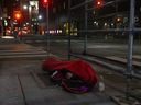A homeless man sleeps on the street, in Toronto, on Friday, March 11, 2022.  