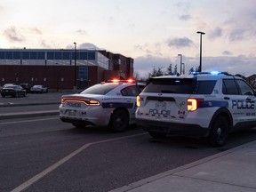 Police cars are pictured at the scene of a shooting at Castlebrooke Secondary School in Brampton, Ont., on Friday, Nov. 18, 2022. A union representing high school teachers in Ontario is calling on the province to provide more funding for training programs and hiring more mental health support staff to address a recent rise in violence in and around schools.