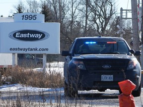 A police cruiser is shown at the entrance to the Eastway Tank company, the scene of an industrial explosion, in Ottawa, Friday, Jan.14, 2022. An Ottawa tanker-truck manufacturer and its owner are facing charges under Ontario's Occupational Health and Safety Act nearly a year after an explosion killed six people.