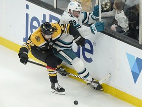 Bruins defenceman Matt Grzelcyk and Sharks left wing Matt Nieto (83) vie for control of the puck in the second period of an NHL game in Boston, Sunday, Jan. 22, 2023.
