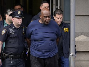 New York City police and law enforcement officials lead subway shooting suspect Frank James, centre, away from a police station in New York, April 13, 2022.