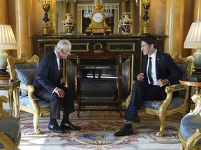 Britain's King Charles III sits with Prime Minister Justin Trudeau, as he receives realm prime ministers in the 1844 Room at Buckingham Palace in London, Sept. 17, 2022.