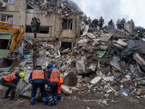 Emergency workers search the remains of a residential building that was struck by a Russian missile on January 15, 2023 in Dnipro, Ukraine.