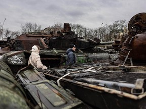 Pedestrians look at destroyed Russian military vehicles at an open air exhibition in Kyiv on January 5, 2023.