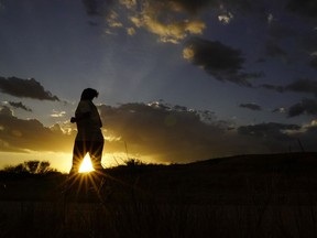 A jogger runs through a park at sunset in San Antonio, Wednesday, Aug. 10, 2022.