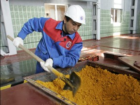 A worker rakes uranium oxide after the opening ceremony of the Zarechnoye mine in southern Kazakhstan Dec. 7, 2006. Zarechnoye was a joint venture between Russia and Kazakhstan.