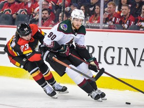 Calgary Flames Tyler Toffoli against Arizona Coyotes J.J. Moser during the third period of NHL action at Scotiabank Saddledome on Monday, December 5, 2022.