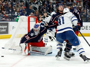 Jean-Francois Berube of the Columbus Blue Jackets makes a save as Andrew Peeke attempts to keep John Tavares of the Toronto Maple Leafs from the rebound during the third period at Nationwide Arena on February 22, 2022 in Columbus, Ohio. Columbus defeated Toronto 4-3 in overtime.