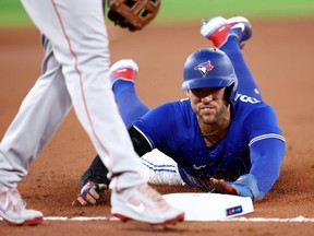 George Springer of the Toronto Blue Jays slides safely into third base on a passed ball by Reese McGuire of the Boston Red Sox in the first inning at Rogers Centre on September 30, 2022 in Toronto, Ontario, Canada.