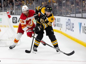 Brad Marchand of the Boston Bruins skates against Noah Hanifin of the Calgary Flames during the first period at the TD Garden on November 10, 2022 in Boston, Massachusetts. The Bruins won 3-1.