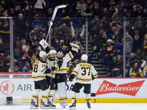 Linus Ullmark #35 of the Boston Bruins celebrates after scoring a goal into an empty net during the third period of their NHL game against the Vancouver Canucks at Rogers Arena on February 25, 2023 in Vancouver, British Columbia, Canada.