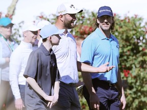Jon Rahm of Spain and NFL Quarterback Aaron Rodgers of the Green Bay Packers walk on the 16th tee during the pro-am prior to the WM Phoenix Open at TPC Scottsdale on February 09, 2022 in Scottsdale, Arizona.