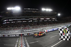 Martin Truex Jr., driver of the #19 Bass Pro Shops Toyota, takes the checkered flag to win the NASCAR Clash at the Coliseum at Los Angeles Memorial Coliseum on February 05, 2023 in Los Angeles, California. (Photo by Meg Oliphant/Getty Images)