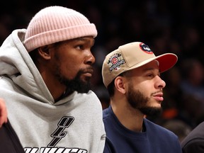 Kevin Durant #7 of the Brooklyn Nets watches alongside Seth Curry #30 on the bench during the game against the LA Clippers at Barclays Center on February 6, 2023 in New York City.