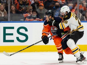 Edmonton Oilers’ Jesse Puljujarvi battles Boston Bruins’ Derek Forbort during third period NHL action at Rogers Place in Edmonton, on Thursday, Dec. 9, 2021. Photo by Ian Kucerak