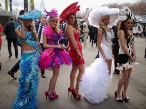 Racegoers enjoy the party atmosphere of Ladies Day and dress to impress at the Aintree Grand National Festival meeting on April 4, 2014 in Aintree, England.