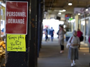 In this file photo, a farmer market stall's help wanted sign is pictured at Atwater Market in Montreal on Oct. 8, 2021.