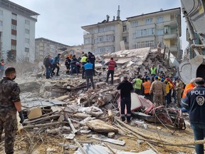 Rescuers carry on search operations among the rubble of collapsed buildings in the Yesilyurt district of Malatya on February 27, 2023 after a 5,6 magnitude earthquake hit eastern Turkey.