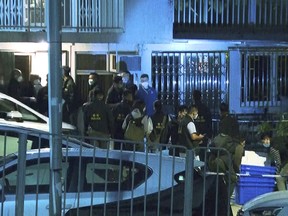 In this image taken from video footage provided by TVB Hong Kong, police officers search a village home where they found body parts related to a missing model in a murder case, in Hong Kong on Sunday, Feb. 26, 2023.