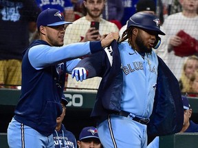 Blue Jays first baseman Vladimir Guerrero Jr. (right) receives the home run jacket from pitcher Jose Berrios (left) after hitting a solo homer against the Cardinals during sixth inning MLB action at Busch Stadium in St. Louis, May 24, 2022.
