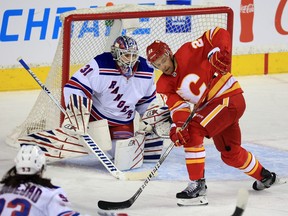 Calgary Flames forward Trevor Lewis looks to grab the puck in front of New York Rangers goaltender Igor Shesterkin during NHL action on Saturday, November 6, 2021.