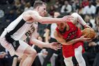 Raptors guard Fred VanVleet tries to avoid San Antonio Spurs centre Jakob Poeltl  during Wednesday night's game in Toronto. Poeltl was traded back to the Raptors the following day. 