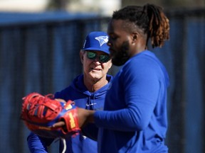 Toronto Blue Jays bench coach Don Mattingly, left, talks with first baseman Vladimir Guerrero Jr. during baseball spring training in Dunedin, Fla., on Tuesday, February 14, 2023.