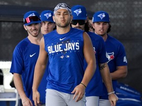 Toronto Blue Jays shortstop Bo Bichette, front, warms up with teammates during baseball spring training in Dunedin.