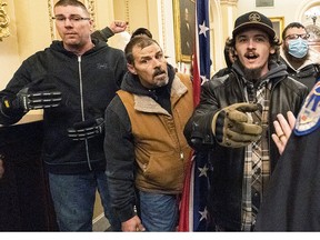 Violent protesters loyal to President Donald Trump, including Kevin Seefried, middle, are confronted by U.S. Capitol Police officers outside the Senate Chamber inside the Capitol, Wednesday, Jan. 6, 2021 in Washington.