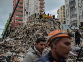 Rescuers search for victims and survivors amidst the rubble of a building that collapsed in Adana on February 6, 2023, after a 7.8-magnitude earthquake struck the country's south-east. - The combined death toll has risen to over 1,900 for Turkey and Syria after the region's strongest quake in nearly a century on February 6, 2023. .(CAN EROK/AFP via Getty Images)