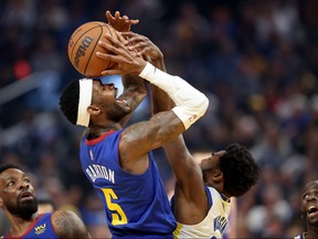 Will Barton of the Denver Nuggets shoots over Andrew Wiggins of the Golden State Warriors in the first half during Game Two of the Western Conference First Round NBA Playoffs at Chase Center on April 18, 2022 in San Francisco, California.