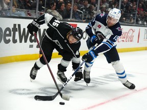 Oct 27, 2022; Los Angeles, California, USA; LA Kings center Blake Lizotte (46) and Winnipeg Jets center David Gustafsson (19) play for the puck in the third period at Crypto.com Arena.