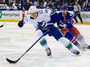Vancouver Canucks defenseman Tyler Myers is chased by New York Rangers left wing Chris Kreider during the second period at Madison Square Garden.