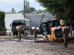 A handout photo taken Thursday, Feb. 16, 2023 and received on Friday, Feb. 17 from the New Zealand Defence Force shows army trucks delivering aid near Napier.