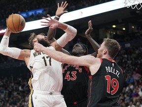 Toronto Raptors forward Pascal Siakam (43) and centre Jakob Poeltl (19) defend against New Orleans Pelicans centre Jonas Valanciunas (17) during the second half at Scotiabank Arena.