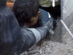 A child is rescued at the site of a damaged building as the search for survivors continues, in the aftermath of the earthquake in Al Atareb, Syria, Tuesday, Feb. 7, 2023 in this picture obtained from social media.
