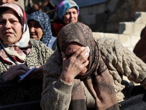 Syrian women weep next to bodies lying on the back of a truck in the town of Jandaris, in the rebel-held part of Aleppo province, following a deadly earthquake, Tuesday, Feb. 7, 2023.
