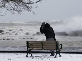 A man navigates high winds on the boardwalk in Toronto's Beach neighbourhood in 2018. High winds are forecast for Toronto on Thursday.