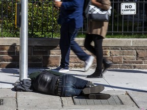 A person sleeps on the street on in downtown Toronto on Oct. 5, 2022.