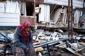 A woman sits amid the rubble following an earthquake in Hatay, Turkey, Tuesday, Feb. 7, 2023.