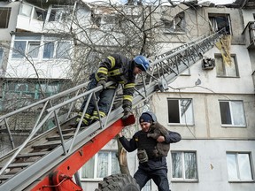 A firefighter rescues a cat after an apartment block was heavily damaged by a missile strike in Pokrovsk, Donetsk region, Ukraine, February 15, 2023.