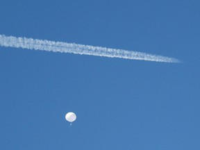 A jet flies by a suspected Chinese spy balloon as it floats off the coast in Surfside Beach, South Carolina, U.S. February 4, 2023.